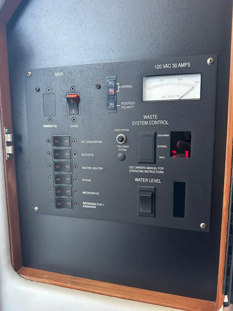 Slide: The Image of Control panel of a 1990 Sea Ray 310 Sundancer boat, featuring various system controls. - 30