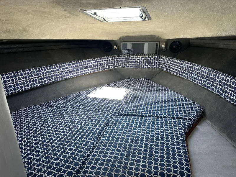 Slide: The Image of 1990 Sea Ray 310 Sundancer cabin with patterned cushions and overhead hatch. - 35