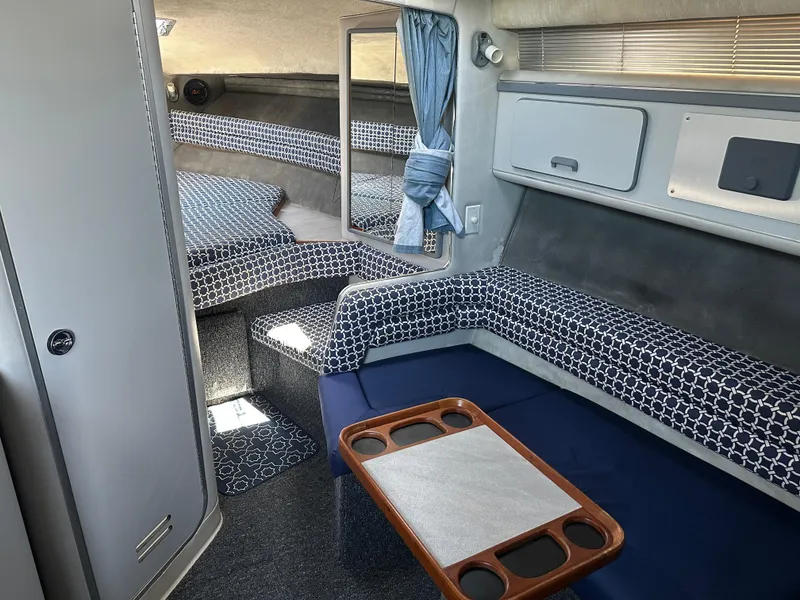 Slide: The Image of Interior of 1990 Sea Ray 310 Sundancer with patterned seating and compact table. - 36