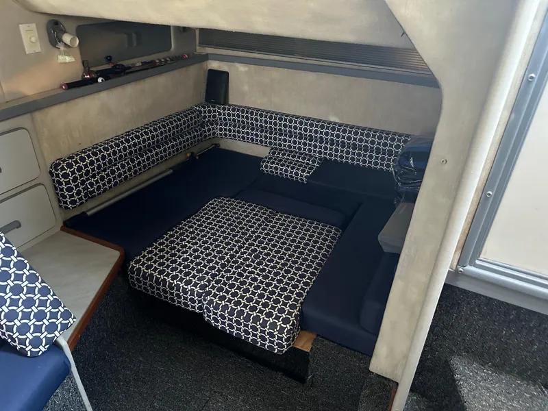 Slide: The Image of 1990 Sea Ray 310 Sundancer cabin interior with patterned seating and cozy layout. - 38