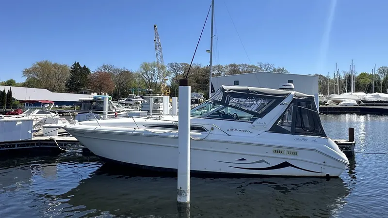 Slide: The Image of 1990 Sea Ray 310 Sundancer boat docked in a marina on a sunny day. - 4