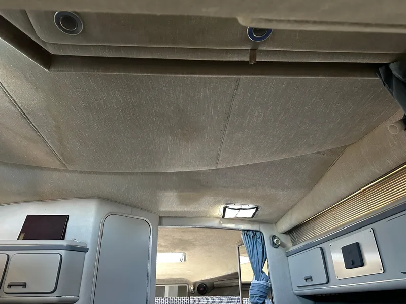 Slide: The Image of Interior cabin of 1990 Sea Ray 310 Sundancer with beige ceiling and storage compartments. - 41