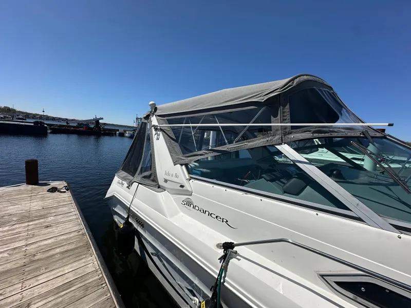 Slide: The Image of 1990 Sea Ray 310 Sundancer docked at a marina under clear blue skies. - 8