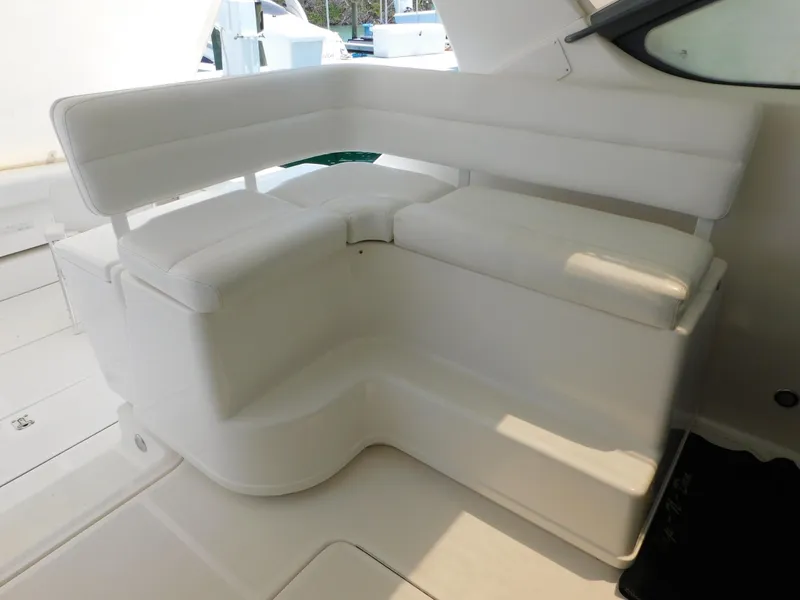 Slide: The Image of 2001 Tiara Yachts 3800 Open interior seating, featuring white cushioned L-shaped design. - 13