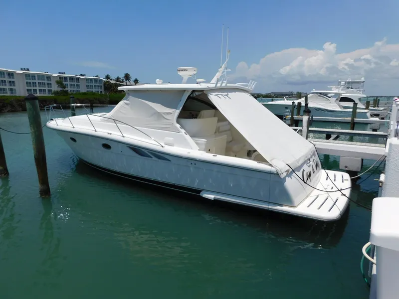 Slide: The Image of 2001 Tiara Yachts 3800 Open docked in a marina under a clear blue sky. - 2