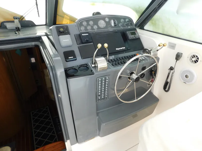 Slide: The Image of 2001 Tiara Yachts 3800 Open helm with steering wheel and navigation controls. - 24