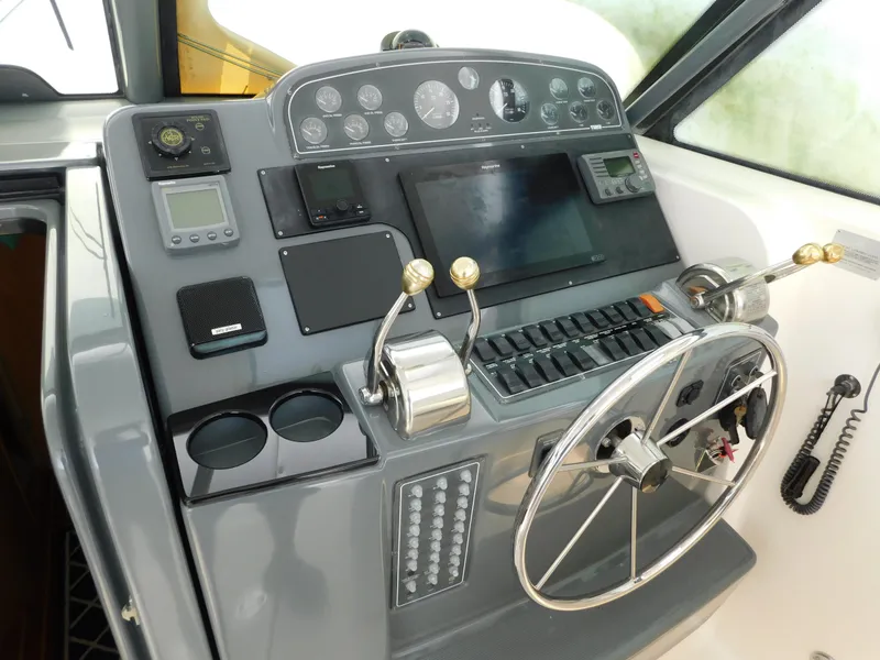 Slide: The Image of Control panel of a 2001 Tiara Yachts 3800 Open, featuring steering wheel and navigation instruments. - 25