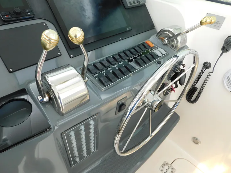 Slide: The Image of Control panel of a 2001 Tiara Yachts 3800 Open with steering wheel and throttle levers. - 26