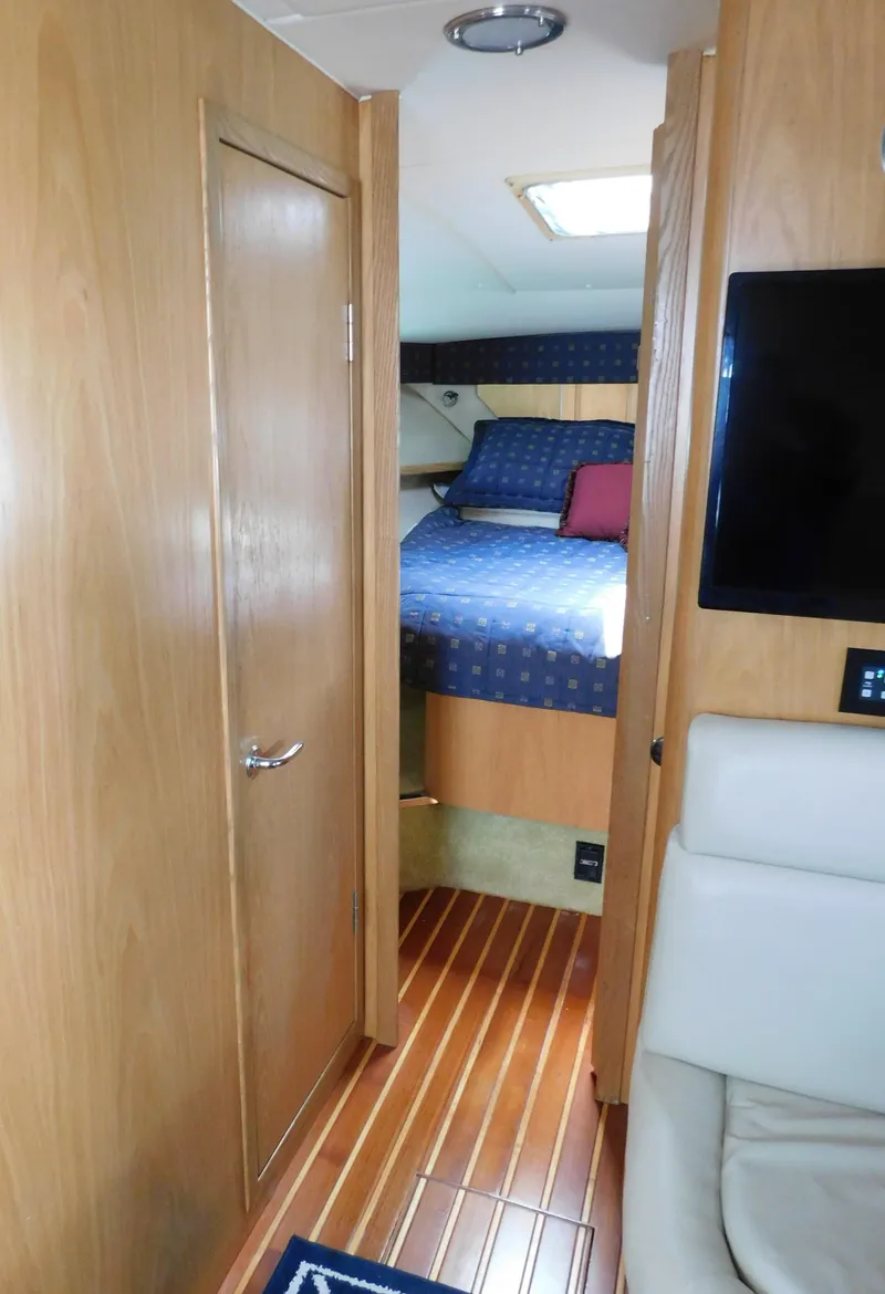 Slide: The Image of 2001 Tiara Yachts 3800 Open cabin interior with bed, wood paneling, and seating. - 40