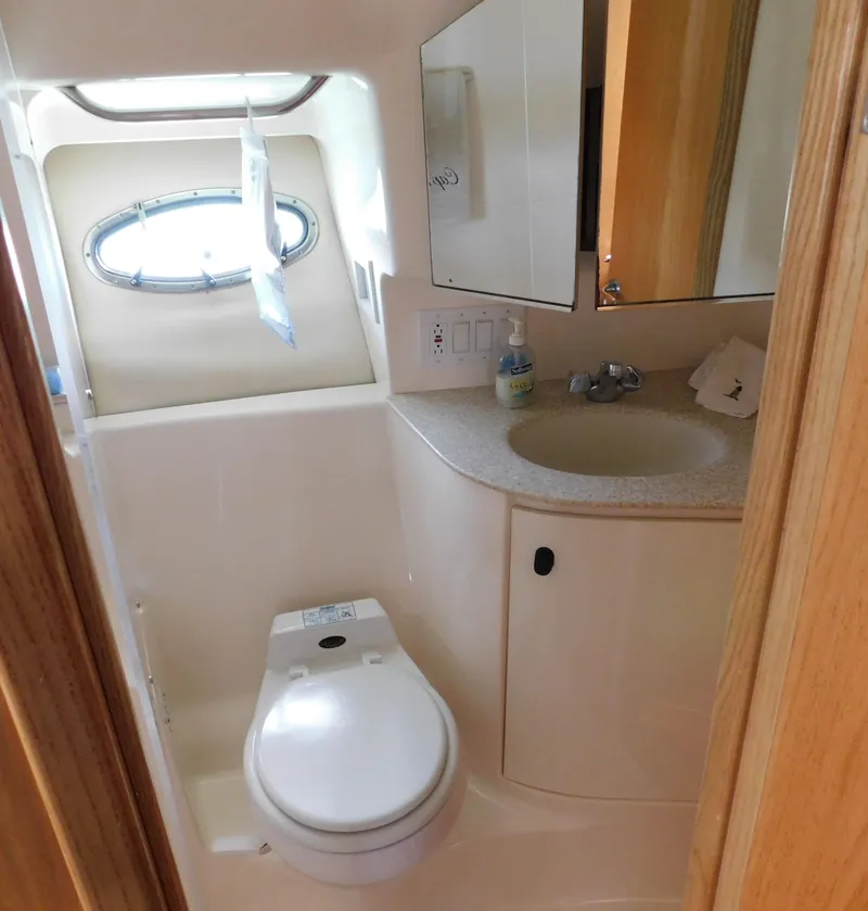 Slide: The Image of 2001 Tiara Yachts 3800 Open bathroom with toilet, sink, and porthole window. - 45