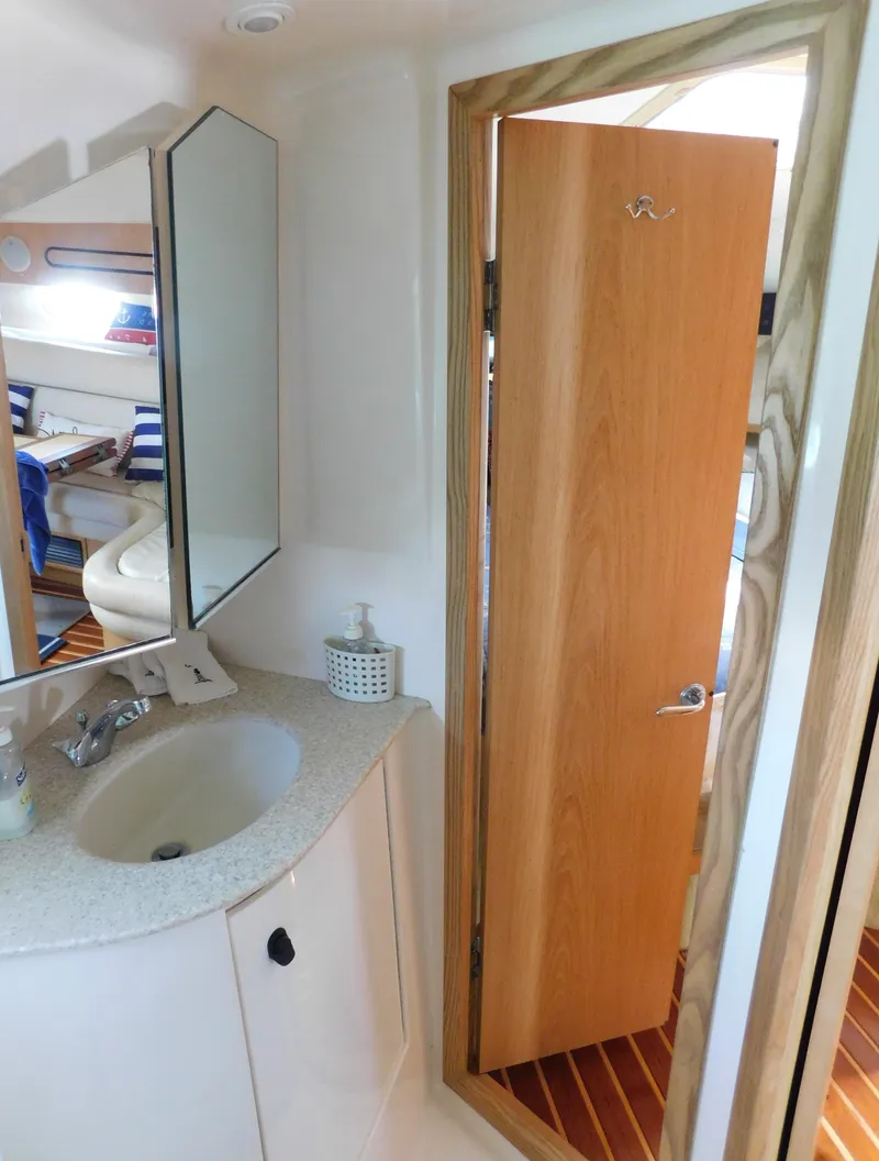 Slide: The Image of 2001 Tiara Yachts 3800 Open bathroom with sink, mirror, and wooden door. - 46