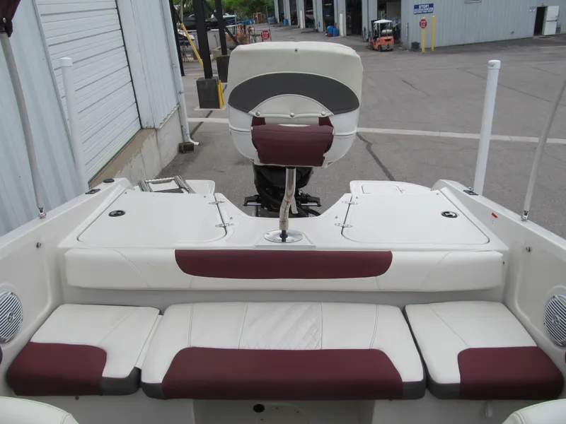 Slide: The Image of 2016 Tahoe 550 TF boat interior with maroon and white seating, docked at a marina. - 11
