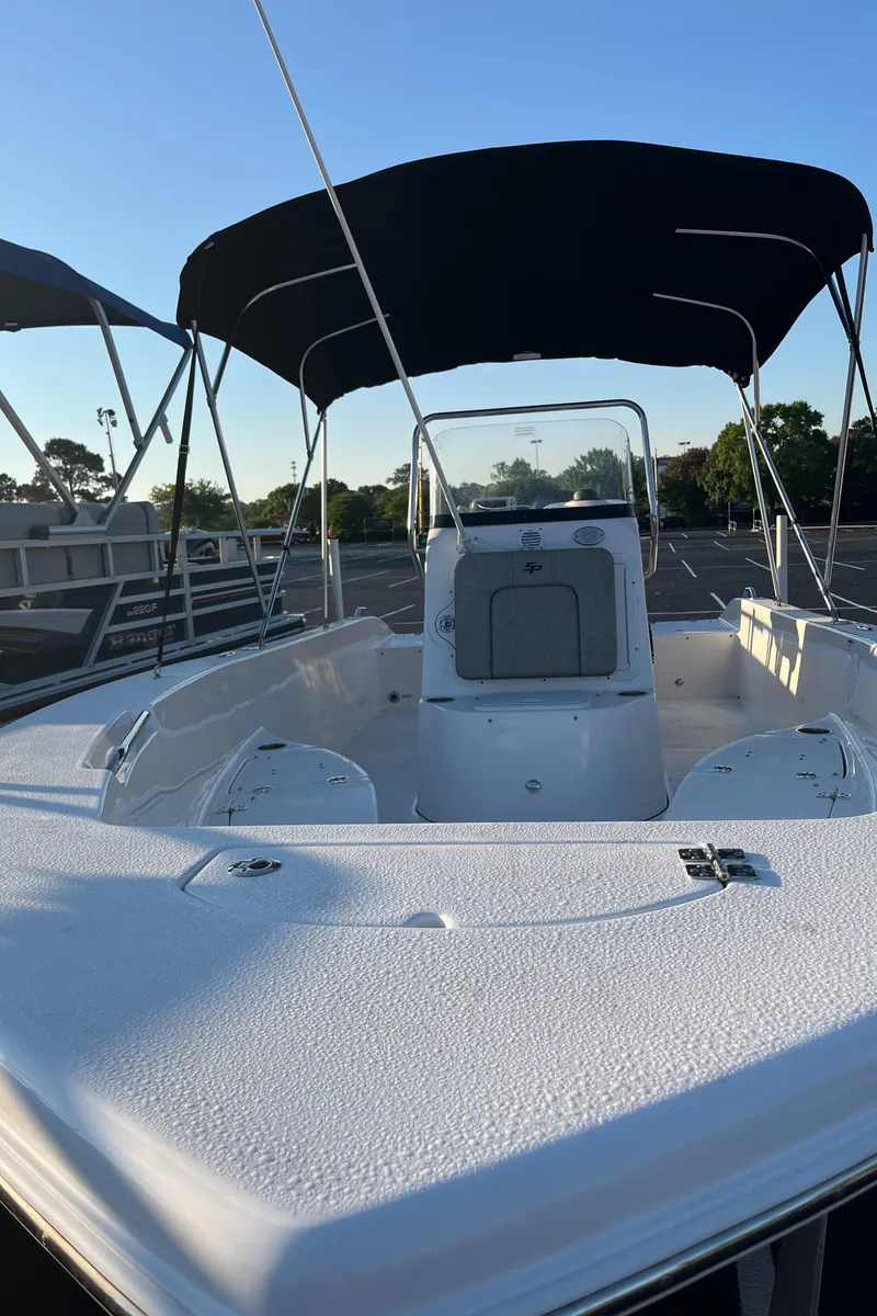 Slide: The Image of 2022 Sea Pro 199 Center Console boat with canopy, parked outdoors. - 2