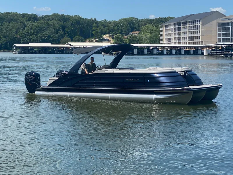 Slide: The Image of 2020 Bennington 30 QSBAX2 pontoon boat on a calm lake, with scenic background. - 2