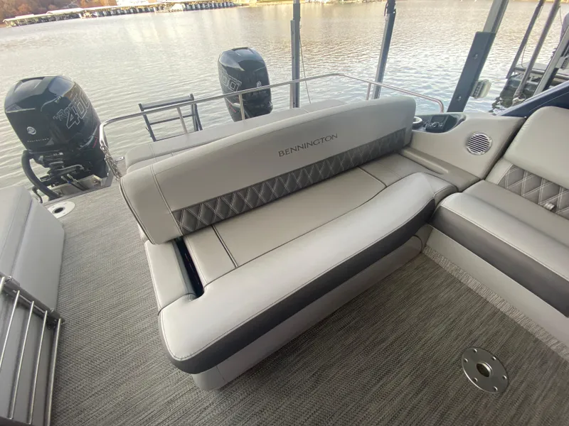 Slide: The Image of 2020 Bennington 30 QSBAX2 pontoon boat interior with plush seating and dual outboard motors. - 22