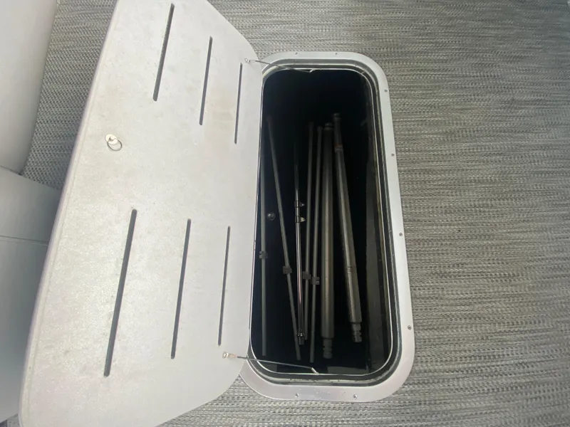 Slide: The Image of Storage compartment on a 2020 Bennington 30 QSBAX2 boat, containing metal rods. - 30