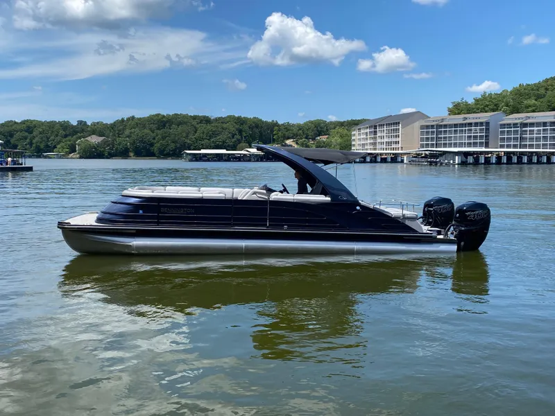 Slide: The Image of 2020 Bennington 30 QSBAX2 pontoon boat on a lake with scenic background. - 4