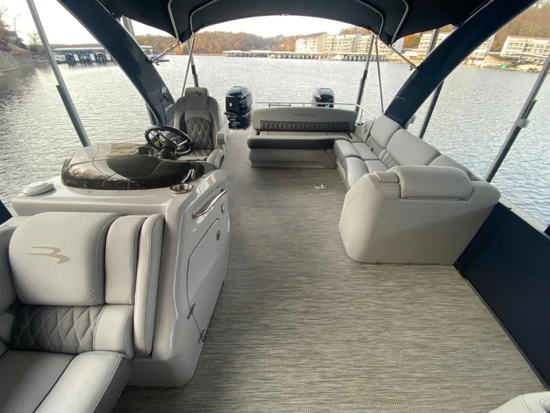 Slide: The Image of 2020 Bennington 30 QSBAX2 pontoon boat interior with luxurious seating on a calm lake. - 47
