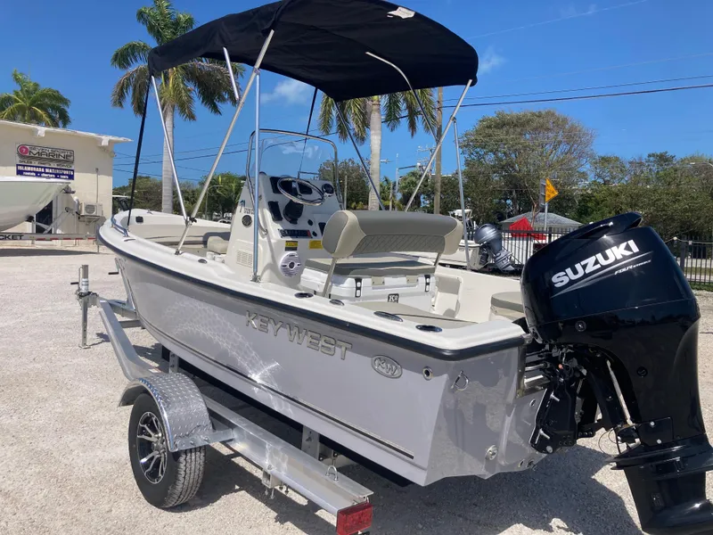 Slide: The Image of 2025 Key West 1720CC boat with Suzuki outboard motor on trailer, parked outdoors. - 4