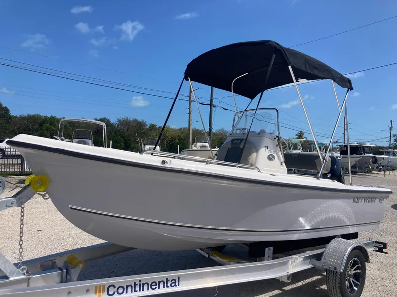 Slide: The Image of 2025 Key West 1720CC boat on trailer with canopy under clear blue sky. - 5