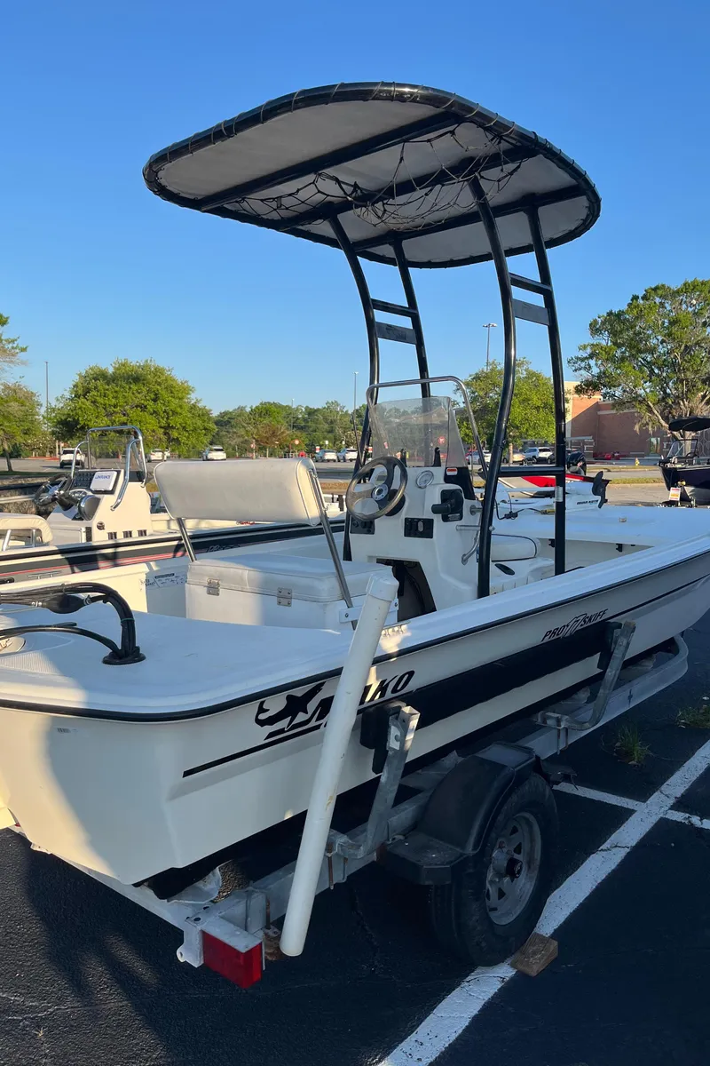 Slide: The Image of 2015 Mako Pro Skiff 17 CC boat with T-top in parking lot. - 2