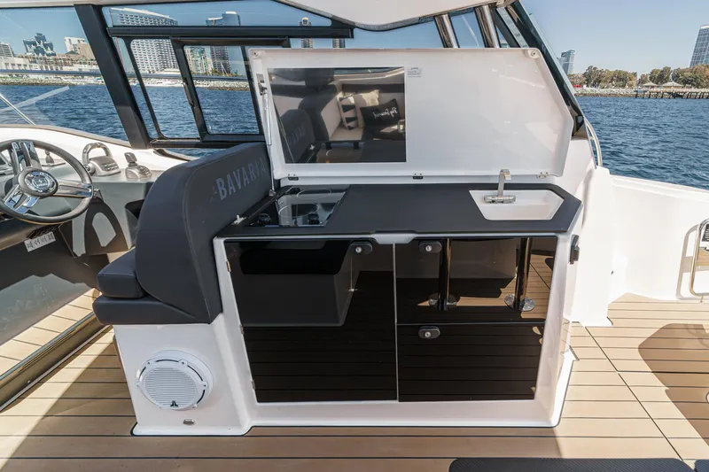 Slide: The Image of 2023 Bavaria SR36 yacht kitchen area with sink and storage, docked by the waterfront. - 29