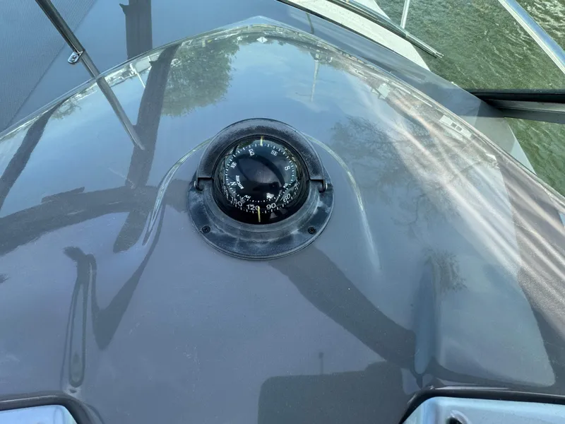 Slide: The Image of Compass on 2011 Monterey 320 Sport Yacht deck, reflecting sky and trees. - 13