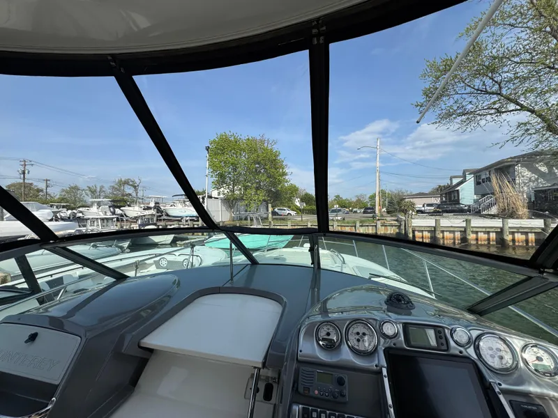 Slide: The Image of Cockpit view of 2011 Monterey 320 Sport Yacht docked by waterfront homes. - 17