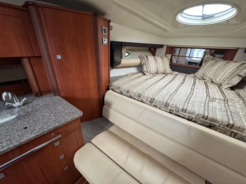 Slide: The Image of Interior of 2011 Monterey 320 Sport Yacht with bed, kitchenette, and wood cabinetry. - 22