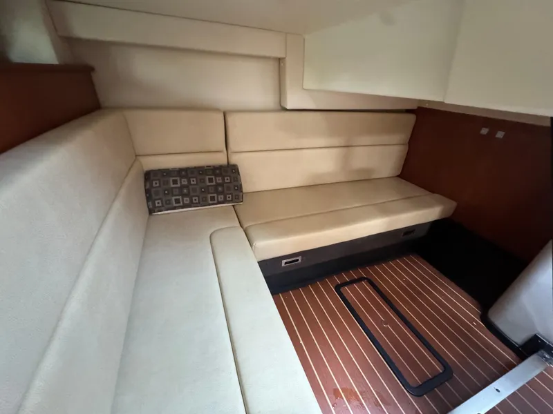 Slide: The Image of Interior of a 2011 Monterey 320 Sport Yacht with beige seating and wooden flooring. - 26