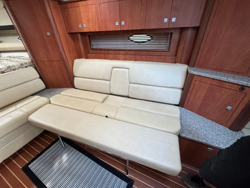 Slide: The Image of Interior of 2011 Monterey 320 Sport Yacht with beige leather seating and wooden cabinetry. - 29