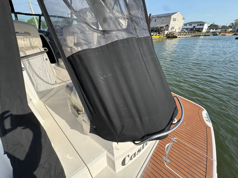 Slide: The Image of 2011 Monterey 320 Sport Yacht with black cover, docked by waterfront homes. - 30