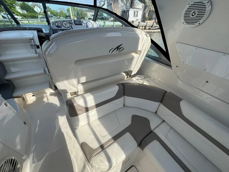 Slide: The Image of Interior of a 2011 Monterey 320 Sport Yacht with cushioned seating and dashboard view. - 6