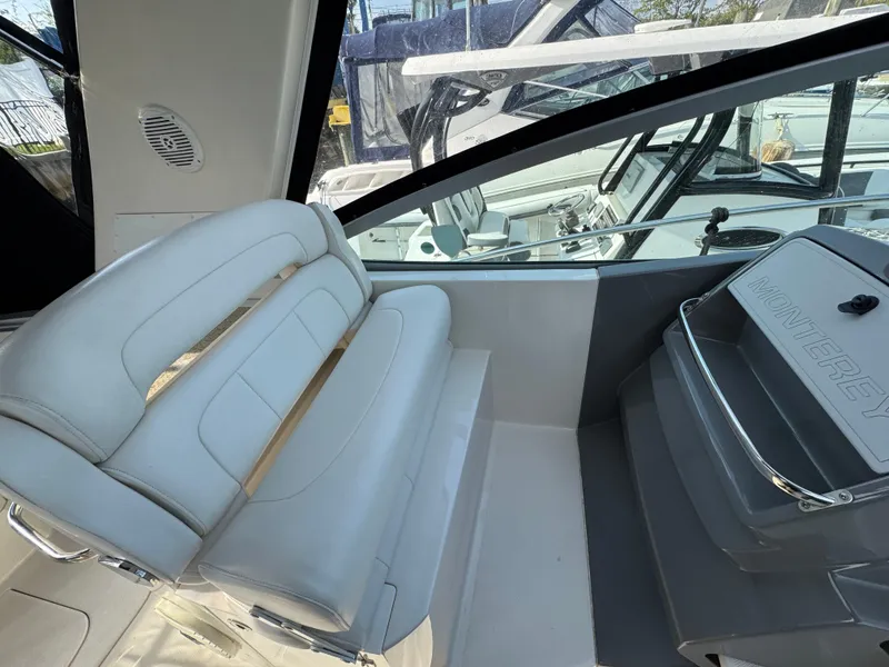 Slide: The Image of 2011 Monterey 320 Sport Yacht interior with white seating and helm station. - 8