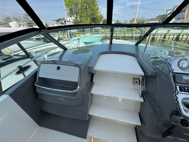 Slide: The Image of 2011 Monterey 320 Sport Yacht helm with steps, docked in a marina. - 9