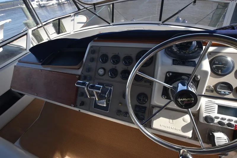 Slide: The Image of 1997 Carver 405 Aft Cabin Motoryacht helm with steering wheel and control panel. - 11