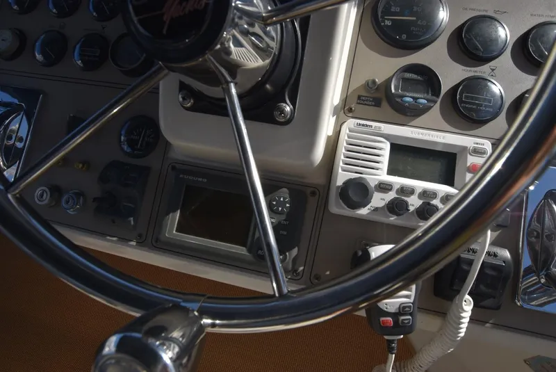 Slide: The Image of 1997 Carver 405 Aft Cabin Motoryacht helm with steering wheel and navigation instruments. - 12