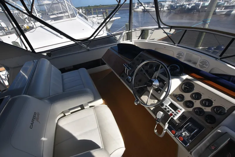 Slide: The Image of 1997 Carver 405 Aft Cabin Motoryacht helm with steering wheel and control panel. - 13