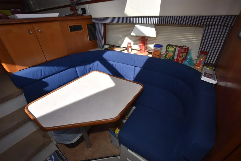 Slide: The Image of 1997 Carver 405 Aft Cabin Motoryacht interior with blue seating and dining table. - 18
