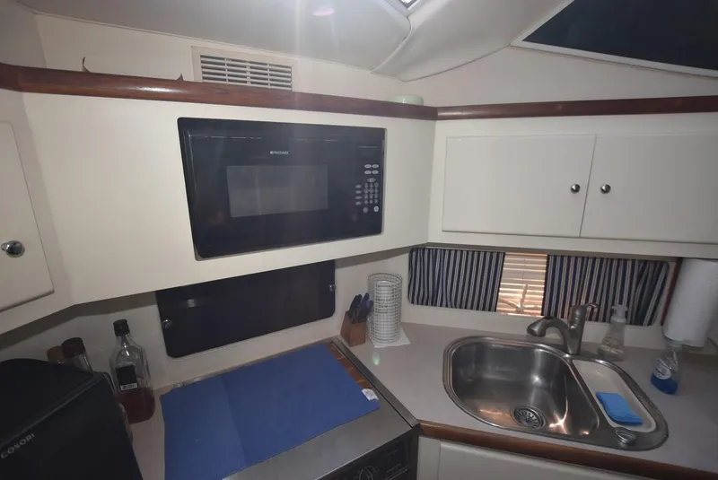 Slide: The Image of 1997 Carver 405 Aft Cabin Motoryacht kitchen with microwave, sink, and storage cabinets. - 20