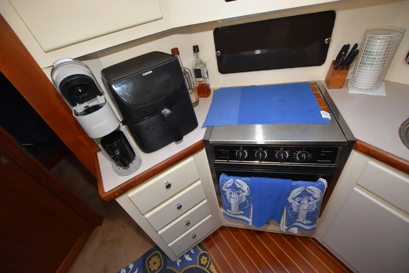 Slide: The Image of 1997 Carver 405 Aft Cabin Motoryacht kitchen with stove, coffee maker, and storage. - 21