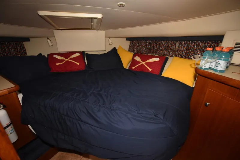Slide: The Image of 1997 Carver 405 Aft Cabin Motoryacht bedroom with cozy bedding and nautical-themed pillows. - 24