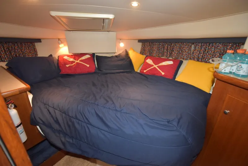 Slide: The Image of Cozy bedroom in 1997 Carver 405 Aft Cabin Motoryacht with blue bedding and colorful pillows. - 26