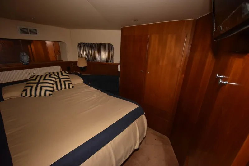 Slide: The Image of 1997 Carver 405 Aft Cabin Motoryacht bedroom with wood paneling and cozy bedding. - 27