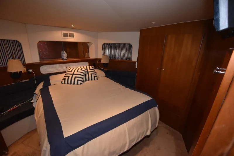 Slide: The Image of 1997 Carver 405 Aft Cabin Motoryacht bedroom with cozy bed and wooden cabinetry. - 30