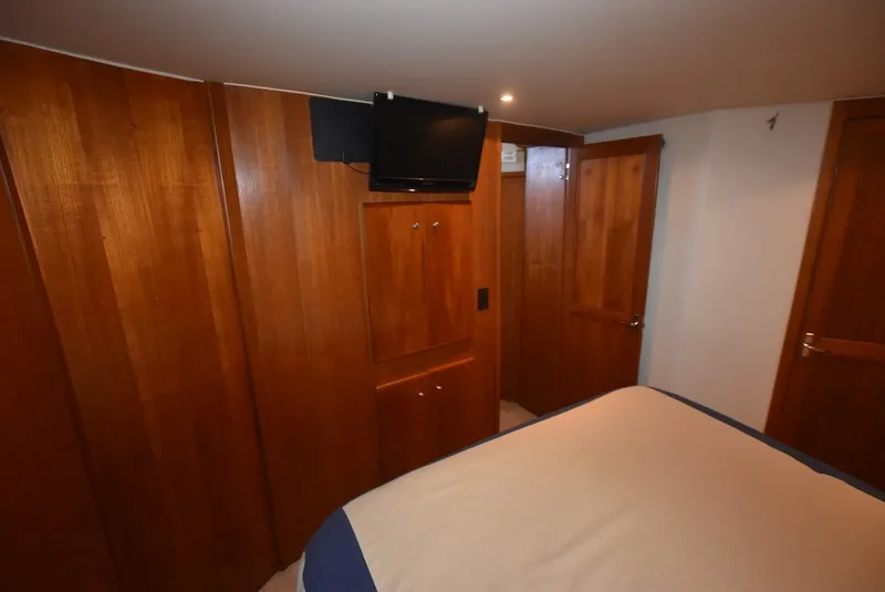 Slide: The Image of 1997 Carver 405 Aft Cabin Motoryacht interior with wood paneling and mounted TV. - 31