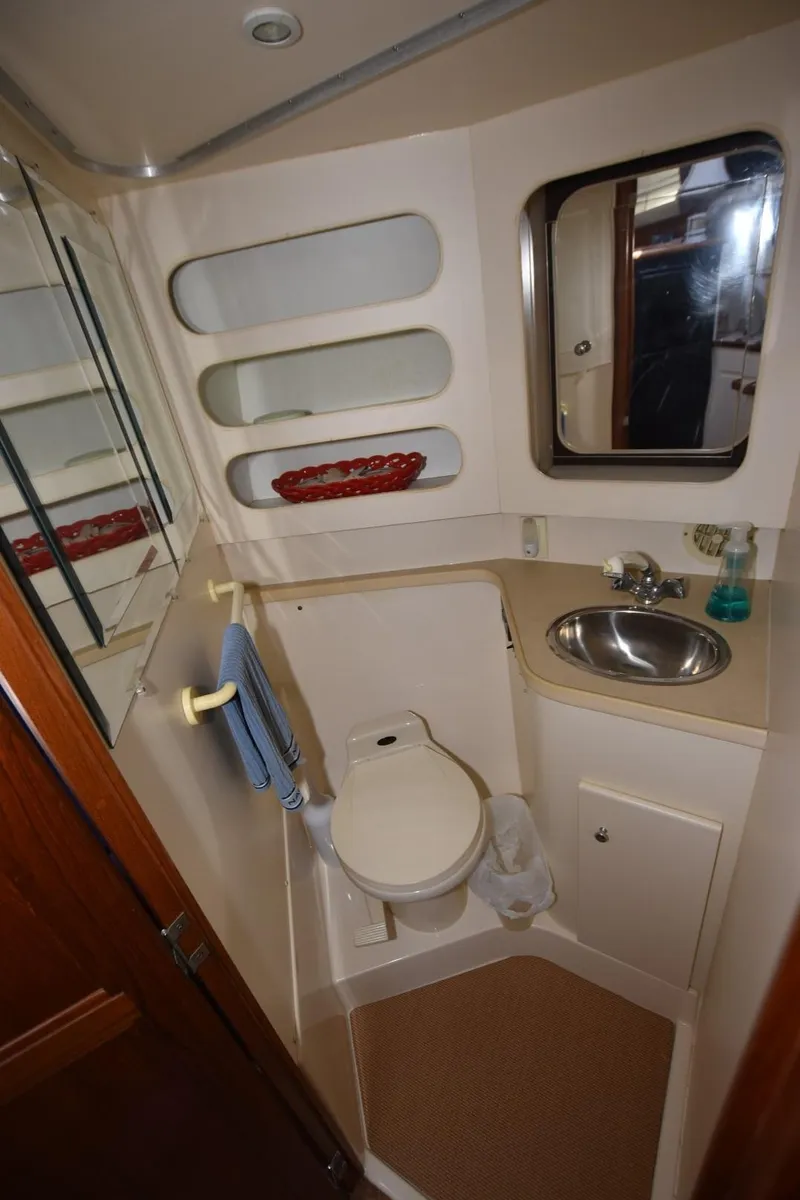 Slide: The Image of 1997 Carver 405 Aft Cabin Motoryacht bathroom with sink, toilet, and mirror. - 33