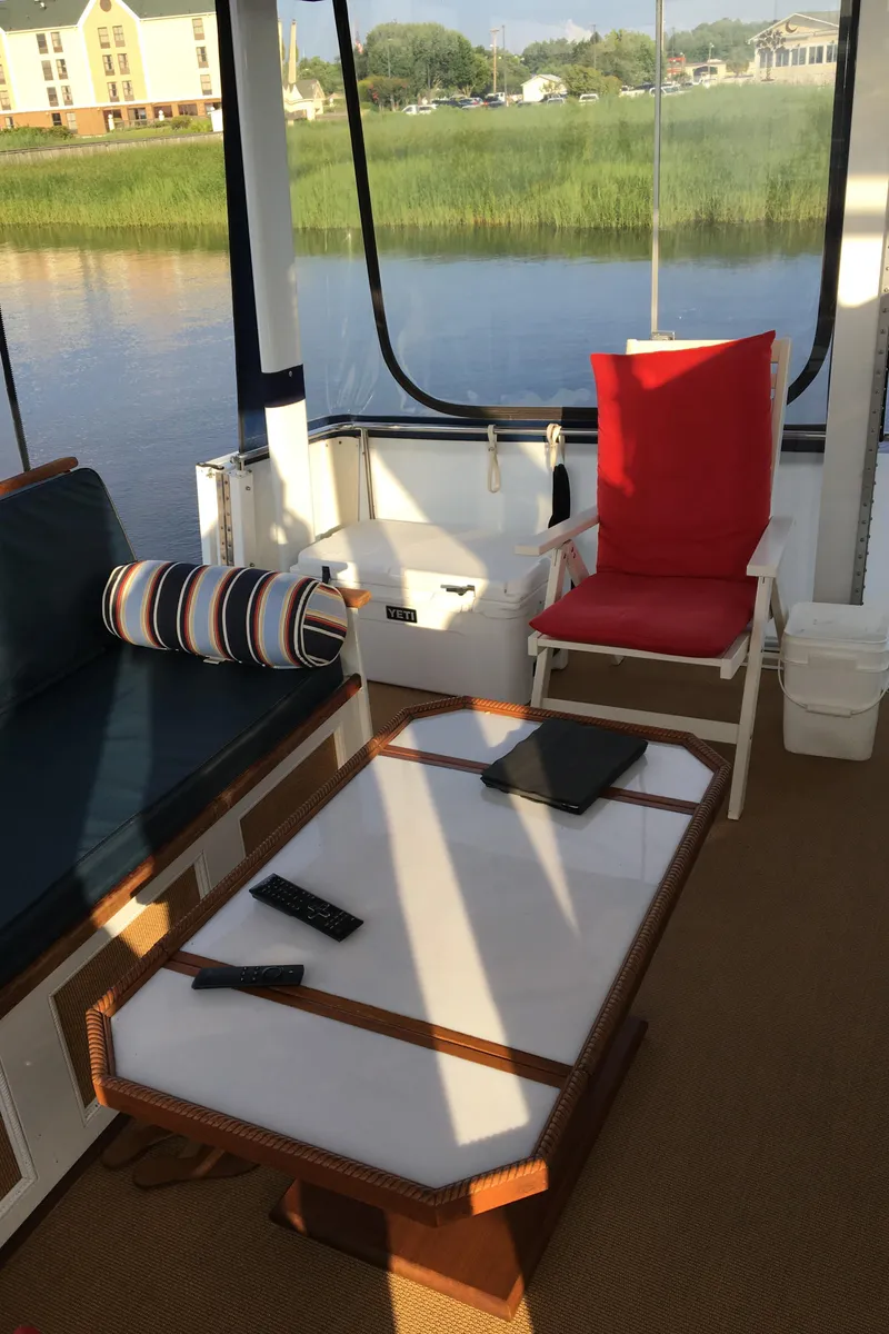 Slide: The Image of 1997 Carver 405 Aft Cabin Motoryacht interior with seating, table, and water view. - 5