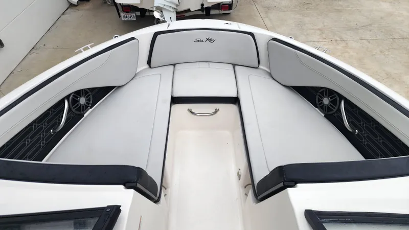 Slide: The Image of 2024 Sea Ray SPX 210 OB boat interior with cushioned seating and sleek design. - 13