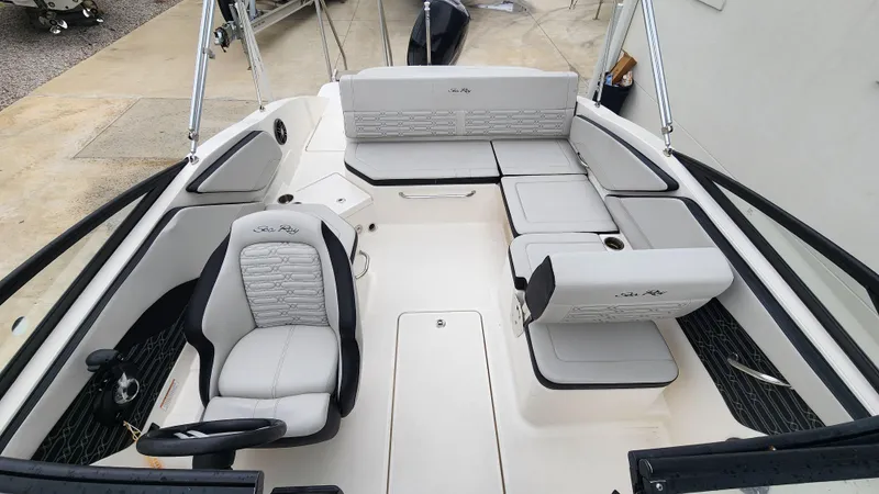 Slide: The Image of 2024 Sea Ray SPX 210 OB boat interior with white seating and steering console. - 7